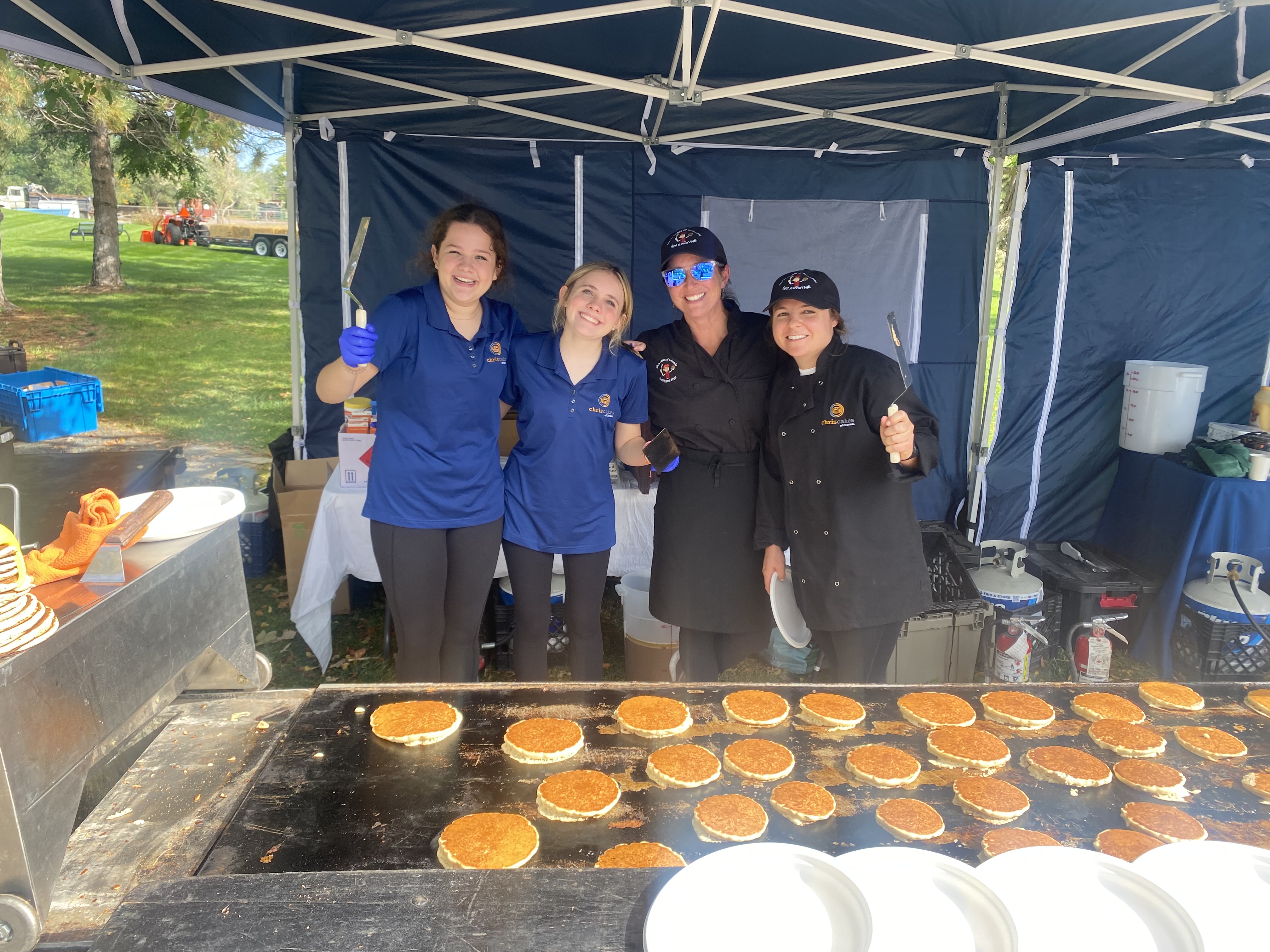 Chris Cakes of Colorado team serving pancakes at an outdoor event
